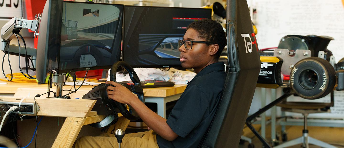 A student seated at a driving simulation